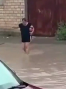 Mujer cruza las inundaciones para comprar un refresco